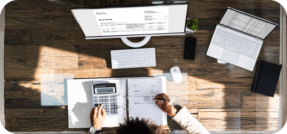 vista superior de una persona sacando calculos en su escritorio frente a su computador